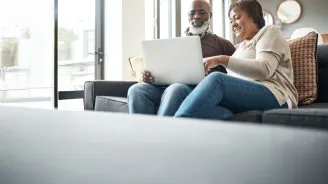 older couple on laptop in living room