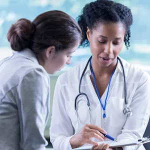 A Physician Goes Over A Chart With Her Patient