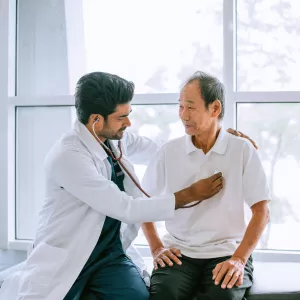 A Physician Listens to His Patients Heart with a Stethoscope