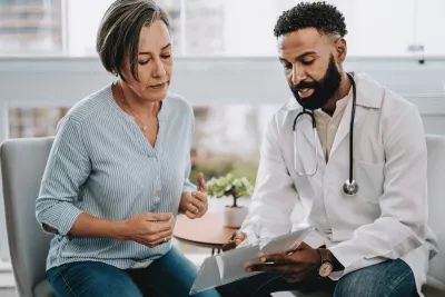 A middle-aged woman speaks to her doctor.