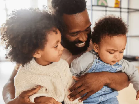 A Father Holds His Two Kids on His Lap
