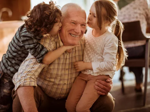 A grandfather plays with his grandchildren.