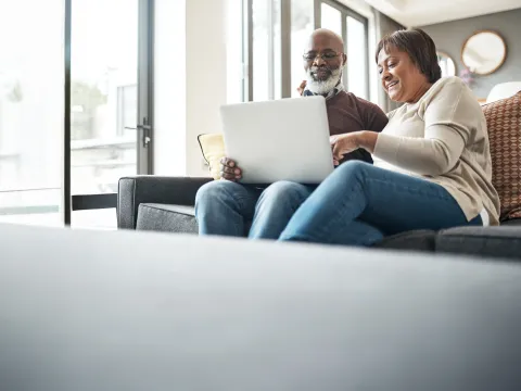 older couple on laptop in living room