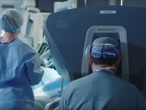 Surgeon and nurse around the da Vinci Robot in a surgery room