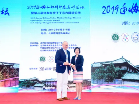 Dr. Robert Holloway receiving an award from a woman