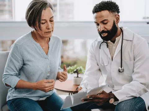 A middle-aged woman speaks to her doctor.