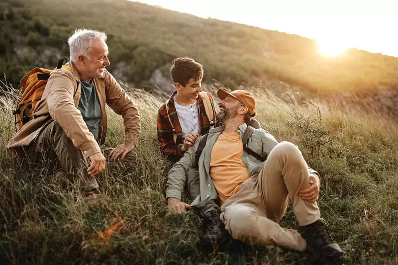 A grandfather, father, and son hiking