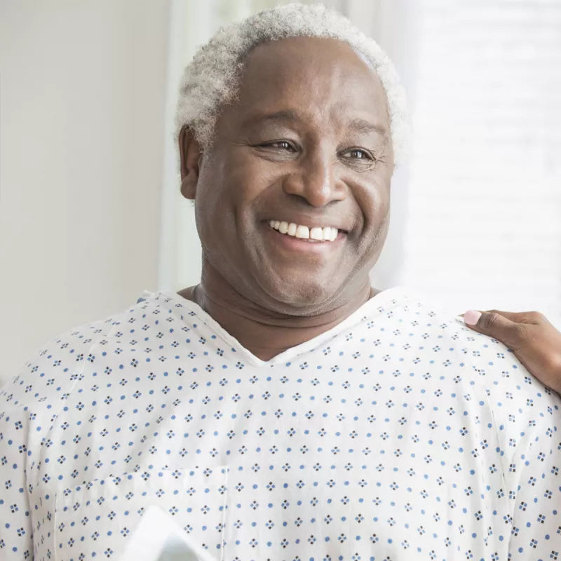 An older African American man receives consolation from a female physician.