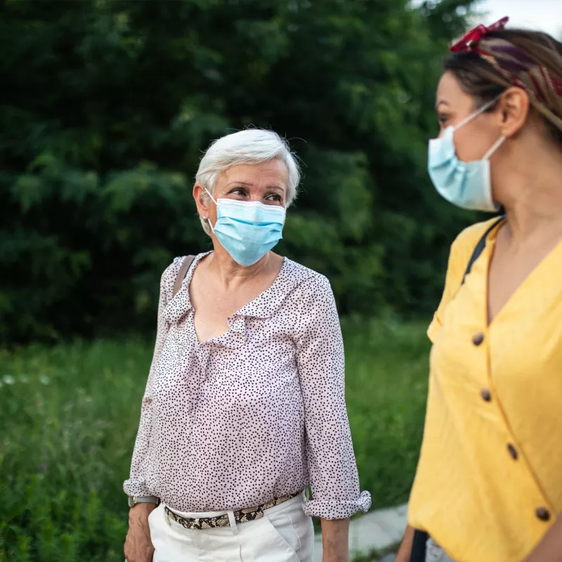 Two ladies talking while wearing masks